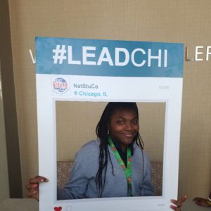 Student posing in large frame with hashtag leadchi